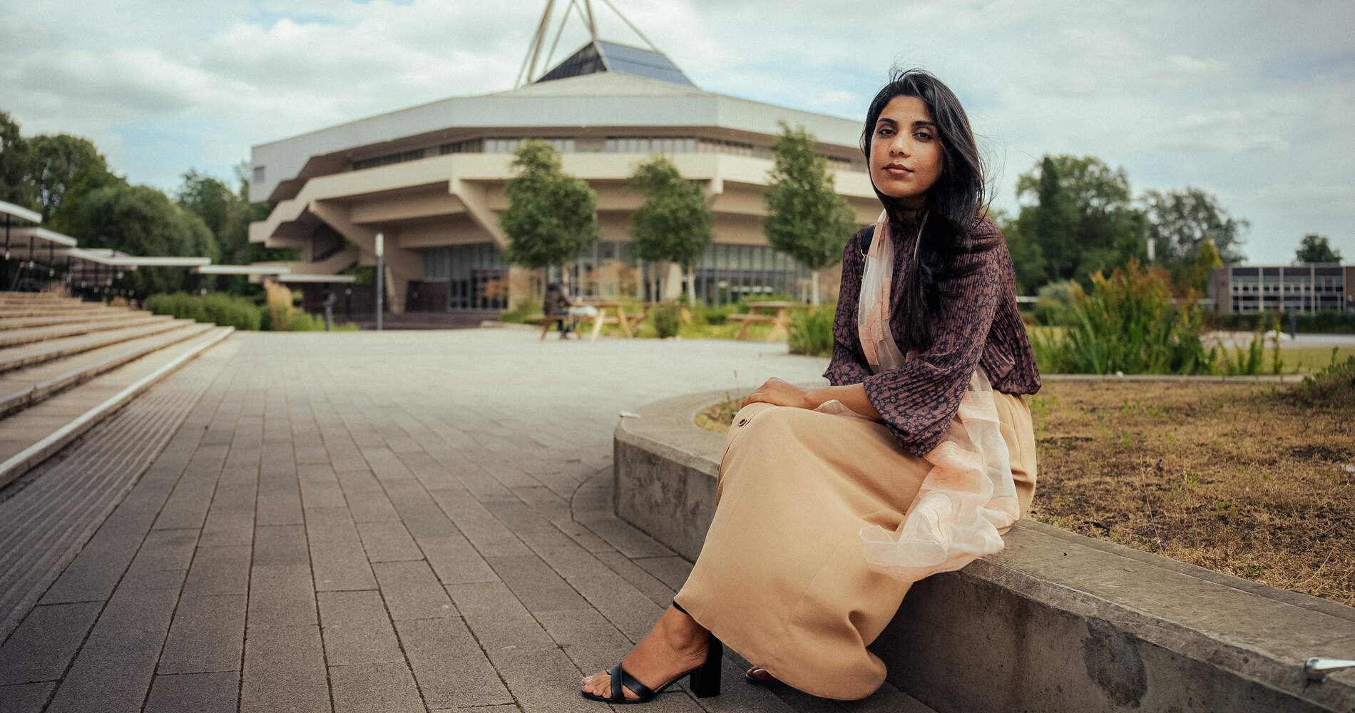 Nazia is sat down and central hall is in the background